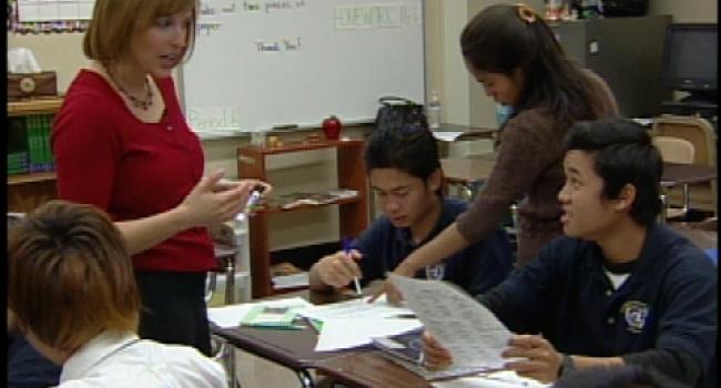 two adults helping two students with their work two adults helping two students with their work