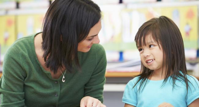 a woman and a girl smiling at each other