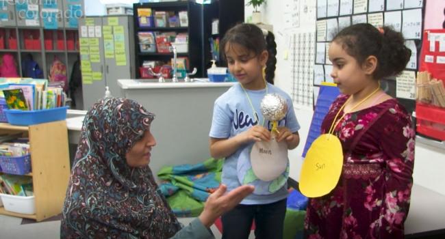 Students present science project to teacher